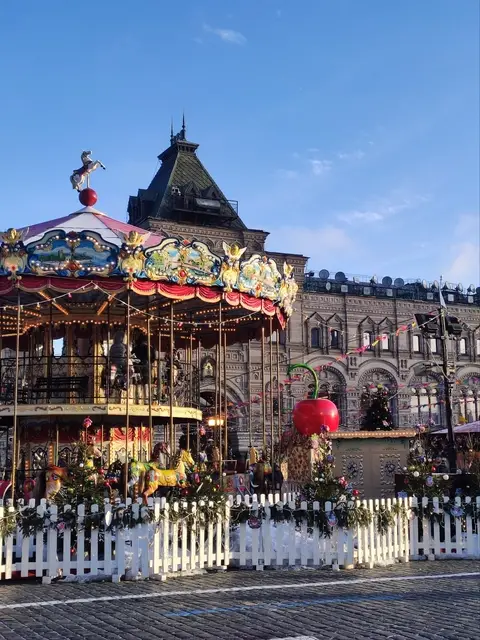 the vintage carousel on red square in front of gum, decorated for the new year